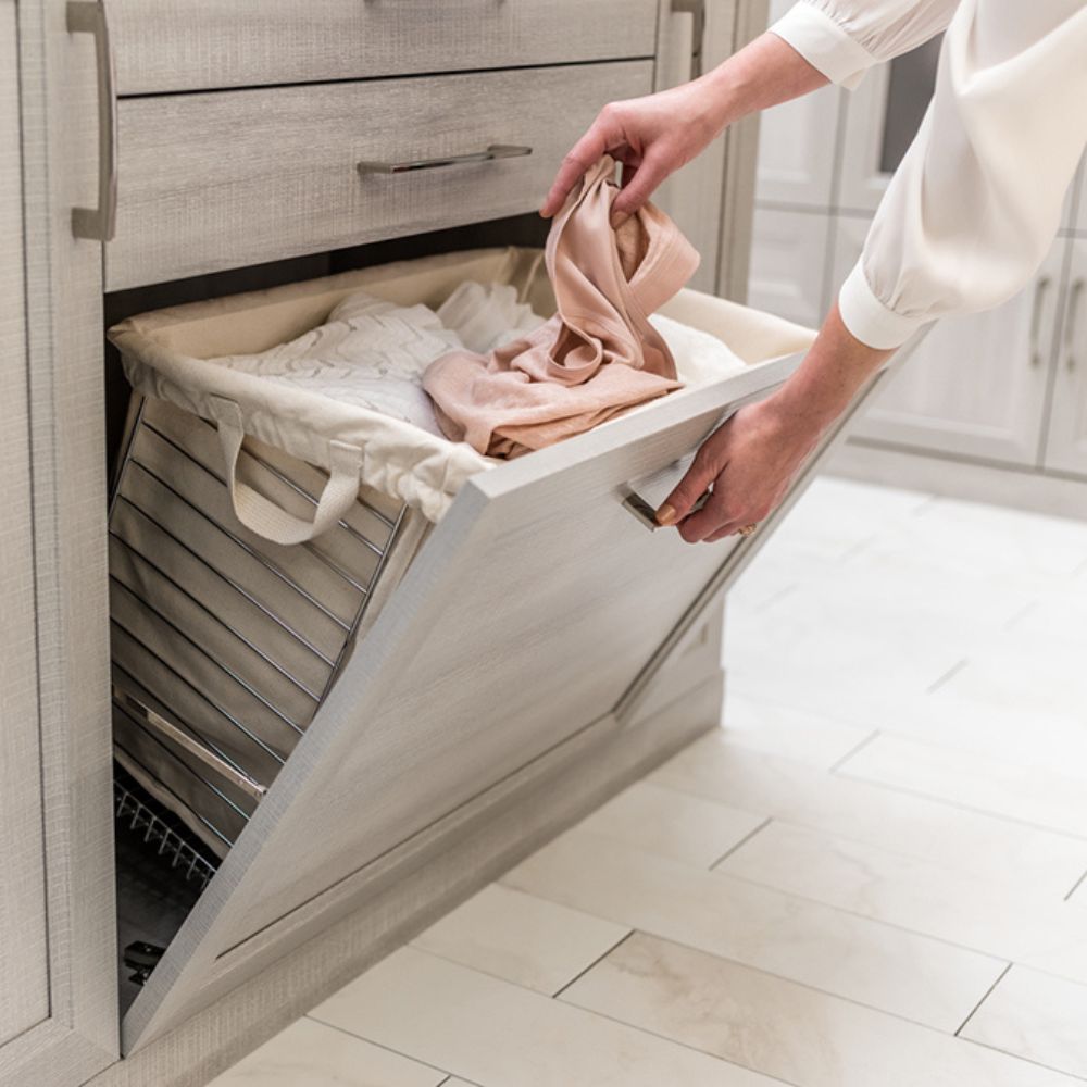 Pull-out hamper drawer built into custom closet system for hidden laundry storage
